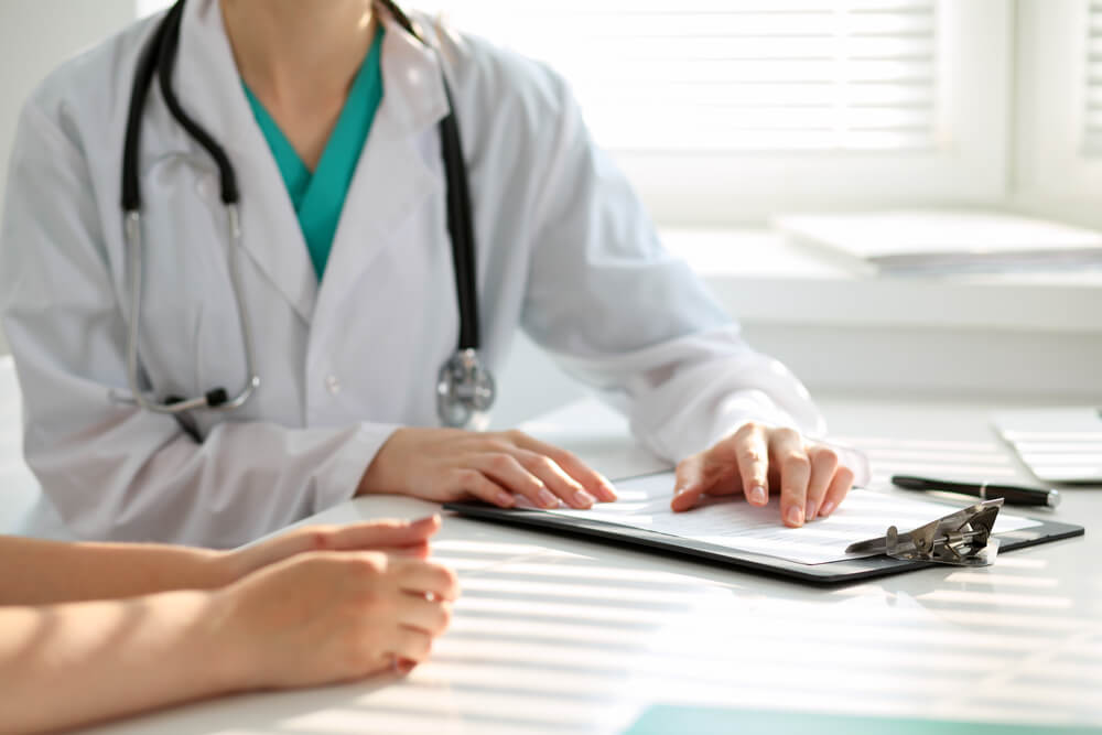 Doctor and Patient Are Discussing Something, Just Hands at the Table