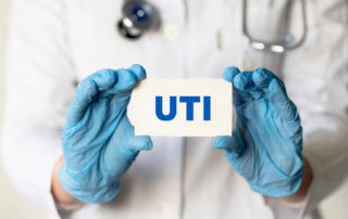 A Medical Worker in Gloves Holds a Card With the Words Uti - Urinary Tract Infection