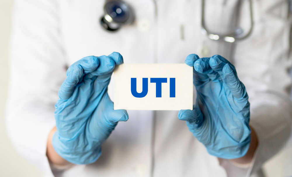 A Medical Worker in Gloves Holds a Card With the Words Uti - Urinary Tract Infection