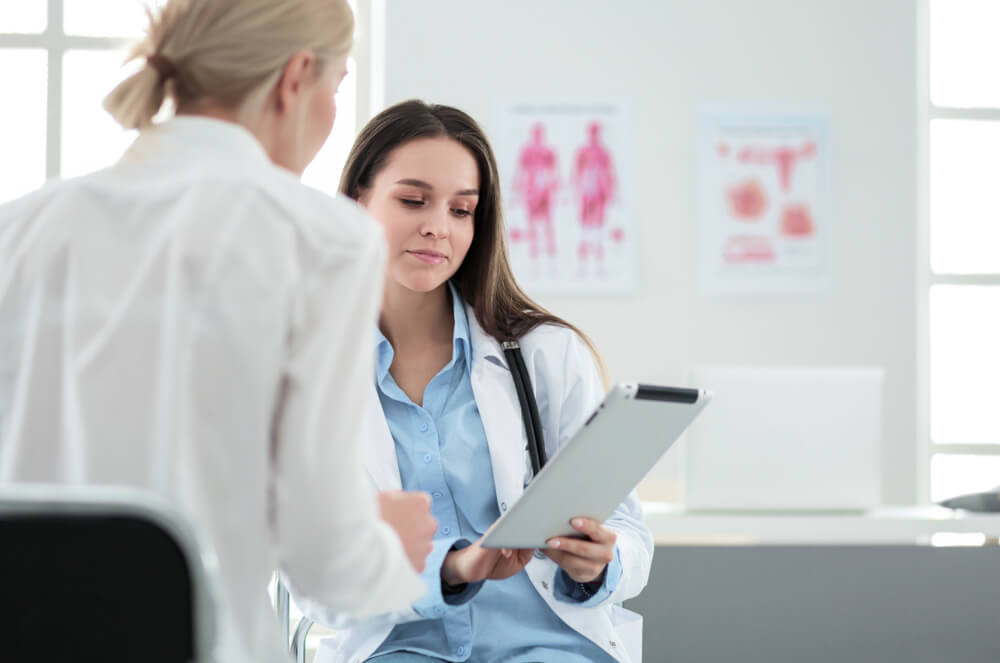 Doctor and Patient Discussing Something While Sitting at the Table.