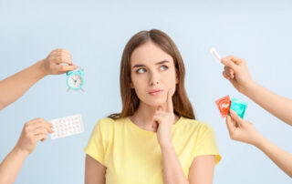 Thoughtful Young Woman and Hands With Different Means of Contraception on Color Background