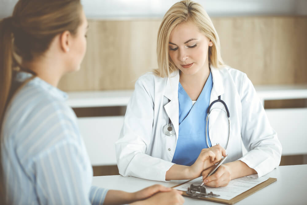 Woman-Doctor and Patient Sitting and Talking in Hospital or Clinic.