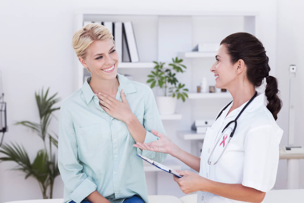 Pink Awareness Ribbon Against Patient Smiling to Her Doctor