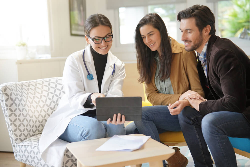 Happy Doctor With Couple Patients in Modern Office