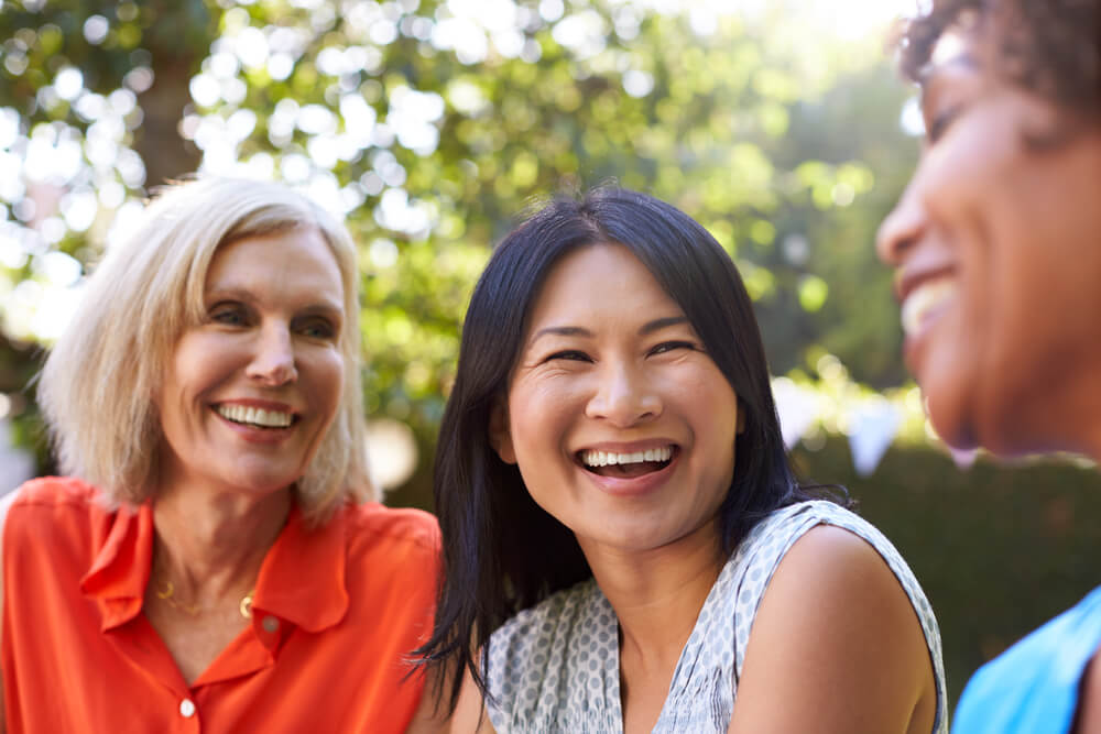 Mature Female Friends Socializing in Backyard Together