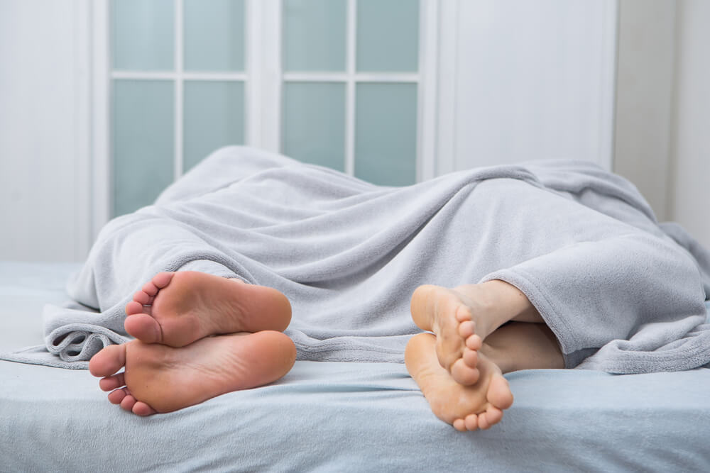 Man and Woman Lying in Bed With Backs Turn to Each Other