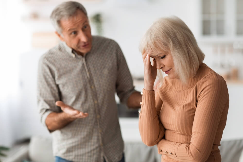 Aggressive Senior Husband Shouting At Wife Having Quarrel Standing In Kitchen At Home