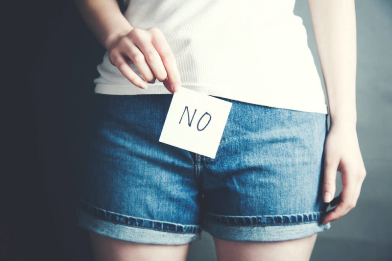 Woman Showing No Sign Next to Her Private Area