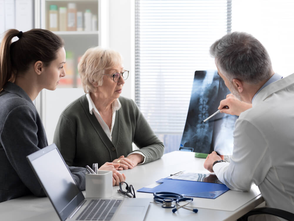 Doctor Checking a Senior Female Patient’s X-Ray Image During a Visit at the Hospital, Injury and Osteoporosis Concept