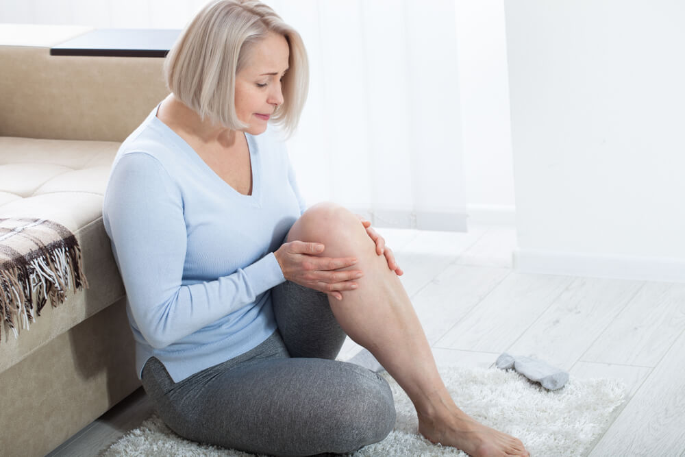 Middle-Aged Woman Suffering From Pain in Leg at Home, Closeup.