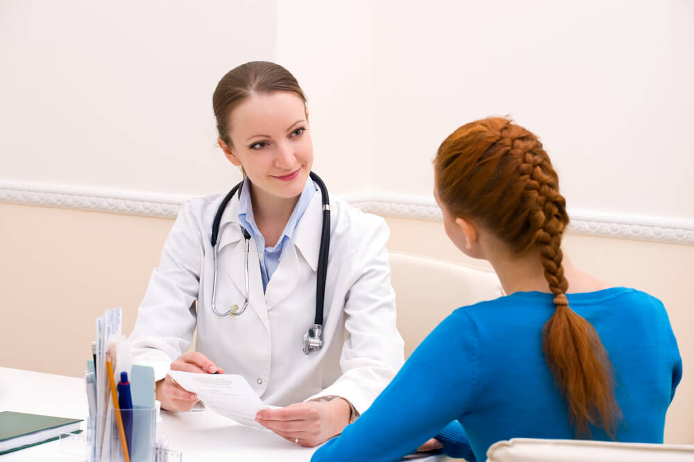 Doctor Advises Woman Patient and Showing Prescription