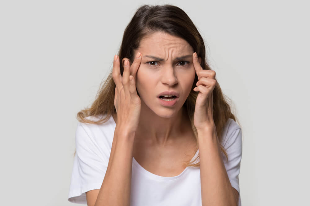 Stressed Young Woman Confused About Facial Wrinkles Aging Skin on Forehead