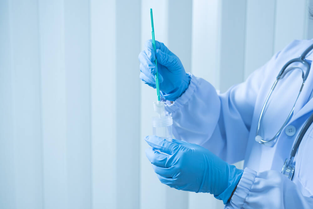 Doctor Hand Holding Liquid Base Cytology Set on Blue Background