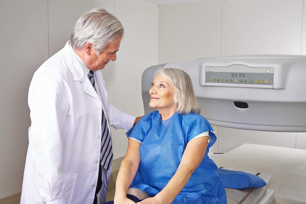 Doctor Talking To Senior Patient Prior to Bone Density Measurement in Radiology