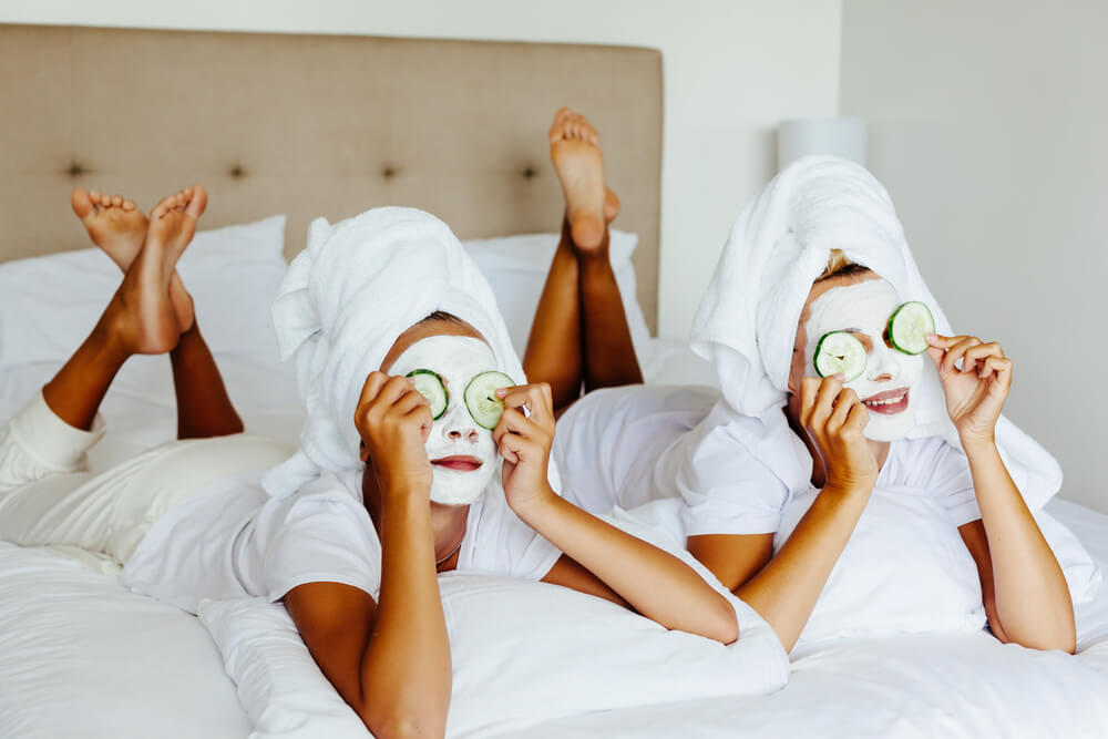 Mom and Her 10 Years Old Preteen Daughter Chilling in the Bedroom and Making Clay Facial Mask.