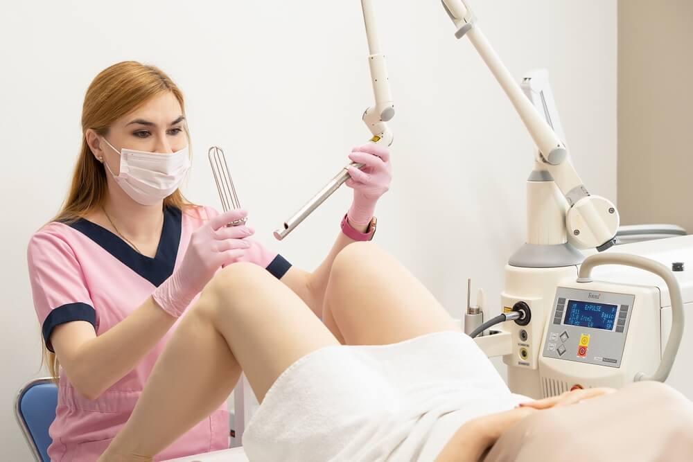 A Female Gynecologist Shows the Patient the Tools That She Will Use for Laser Rejuvenation