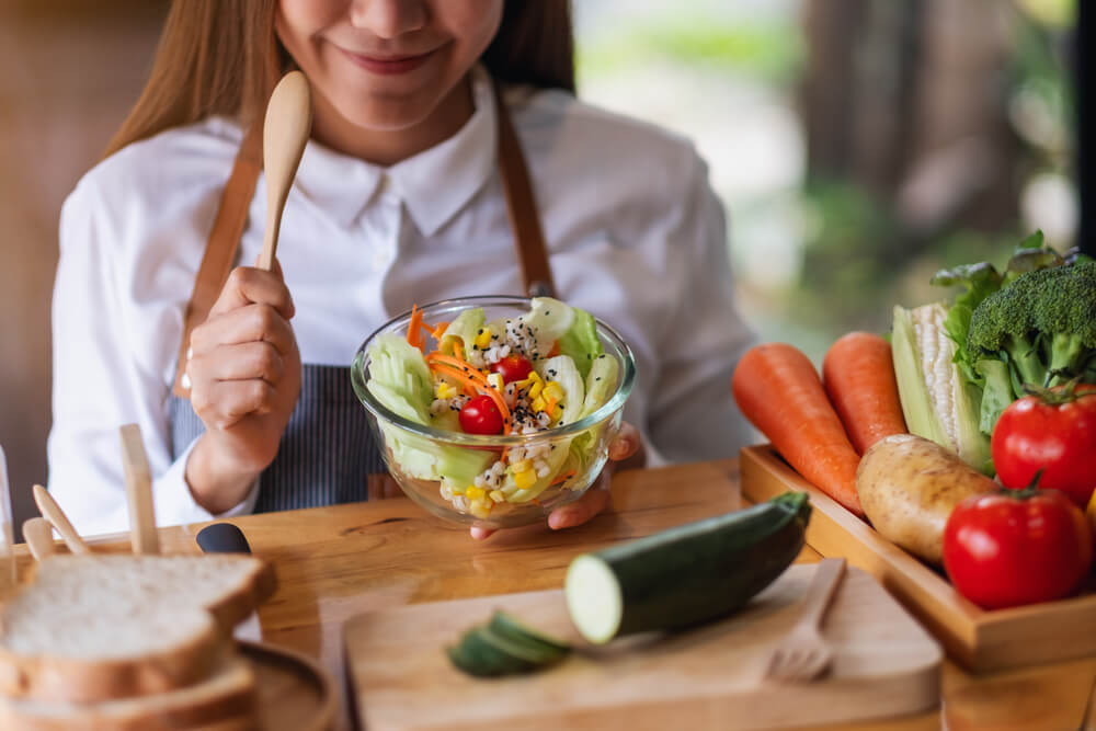 Closeup Image of a Female Chef Cooking Fresh Mixed Vegetables Salad in Kitchen