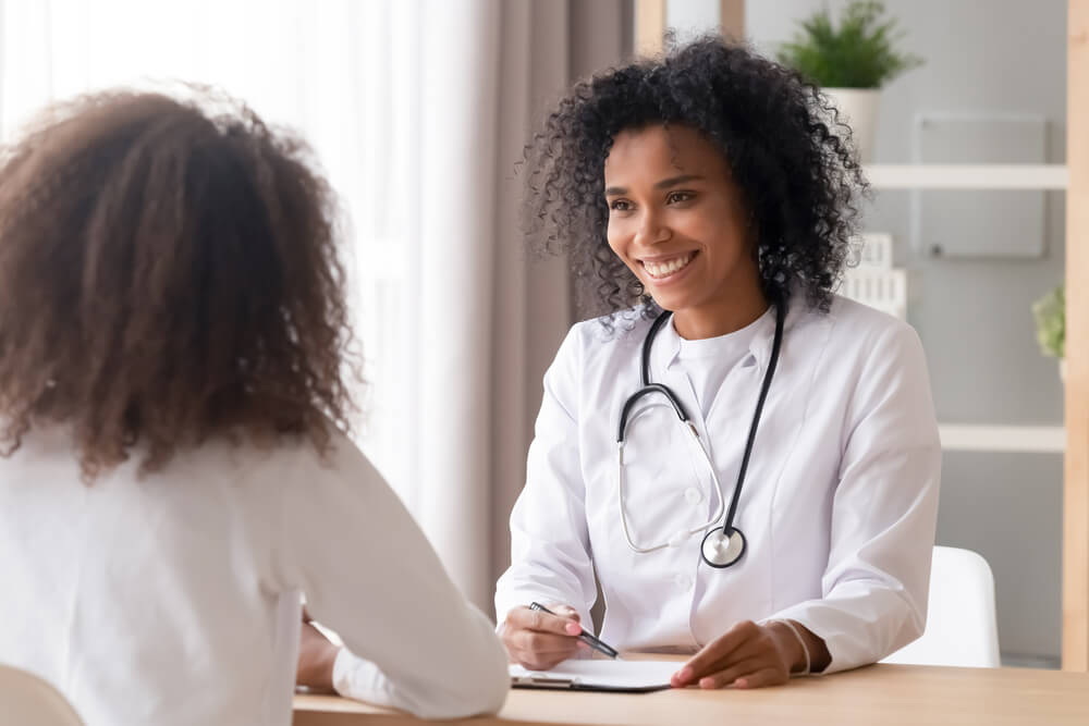 Doctor Talking To Patient Making Notes in Clipboard