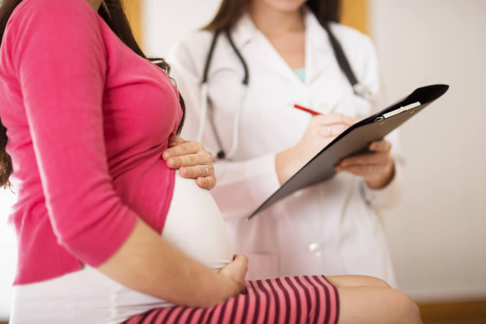 Young Pregnant Woman With Doctor in Hospital