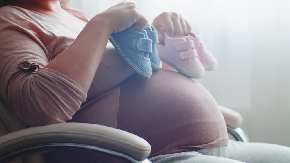 Happy Pregnant Woman Expecting Twins. Pregnant Woman Feeling Happy at Home While Taking Care of Her Child