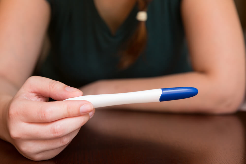 Woman Holding Home Pregnancy Test Anticipating the Result