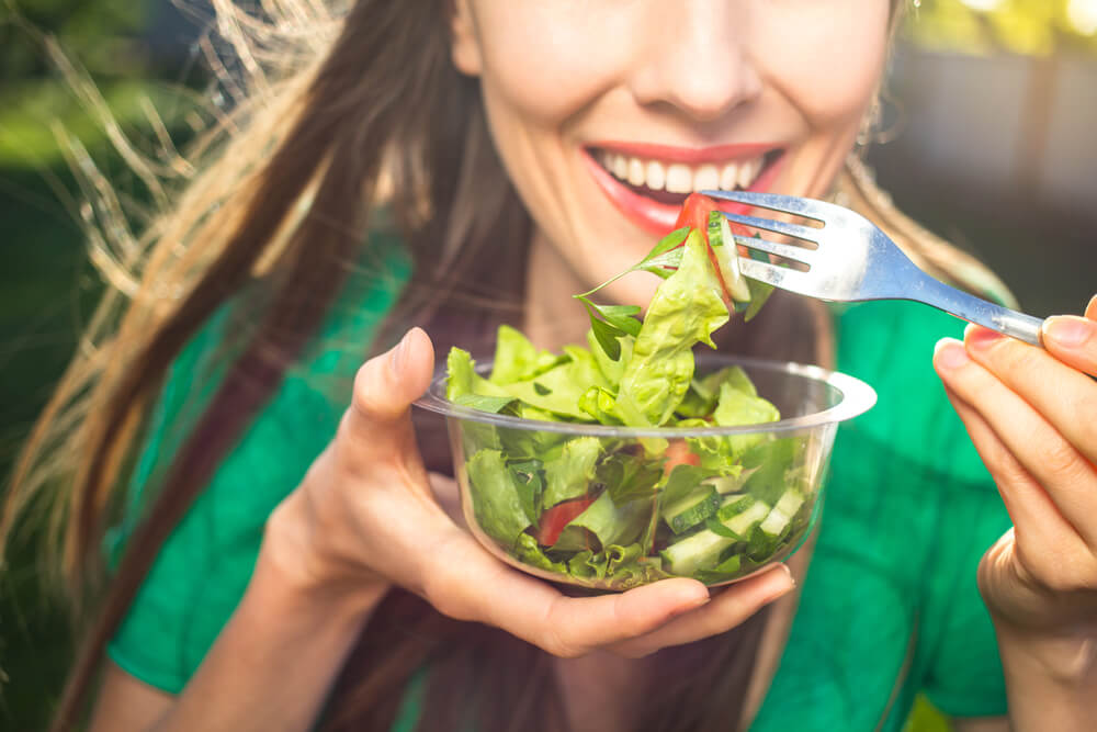 Portrait of Attractive Caucasian Smiling Woman Eating Salad