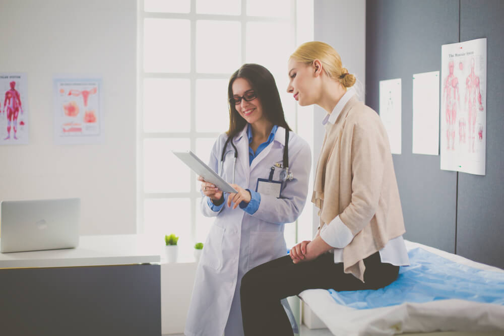 Doctor and Patient Discussing Something While Sitting at the Table