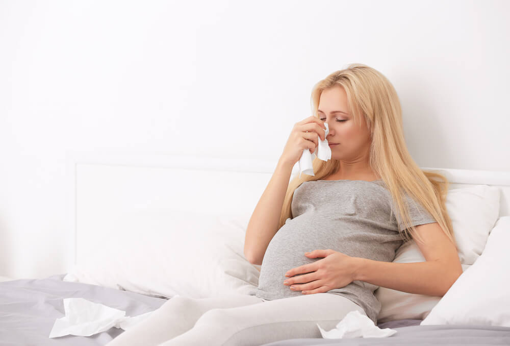 Pregnant Woman With Allergy Sitting on Bed at Home