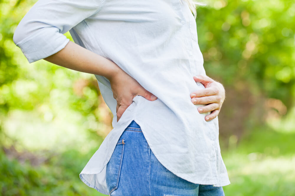 Close Up Picture Of A Pregnant Woman Holding Her Belly In The First Trimester, Outdoor