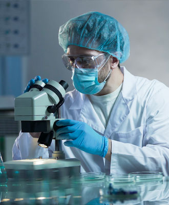 Pathology-Service Doctor In Protective Suit and Glasses Looking Through a Microscope