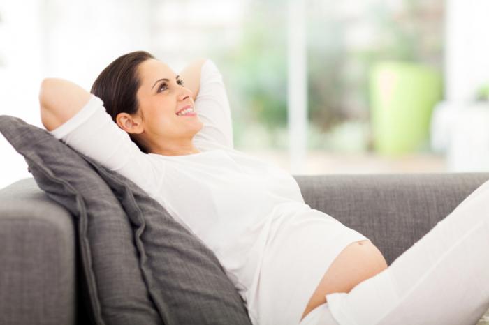 Happy Pregnant Woman Laying on a Sofa