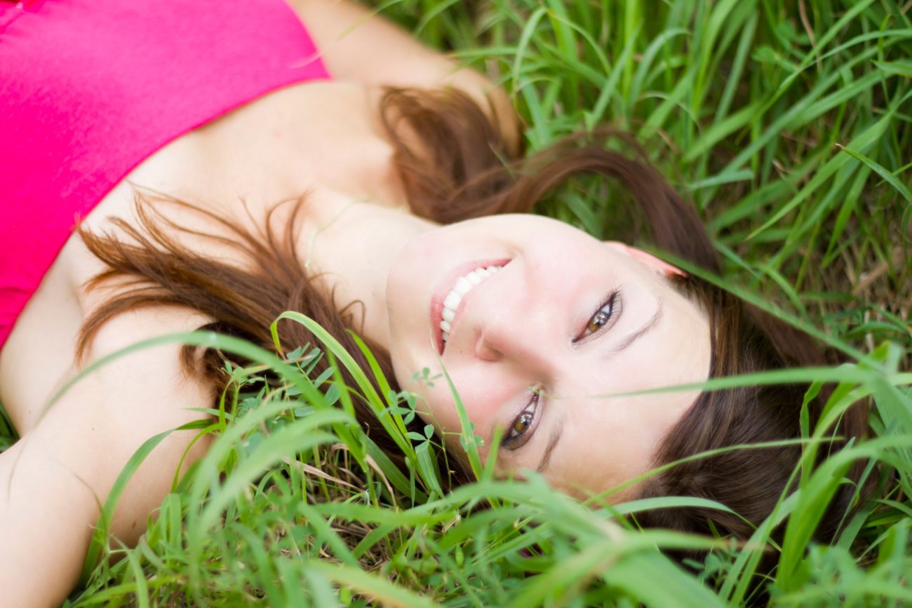 Brown Haired Woman in Pink Shirt Laying in the Grass
