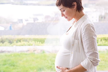 Pregnant Short Haired Woman in White Clothes Standing by the Window