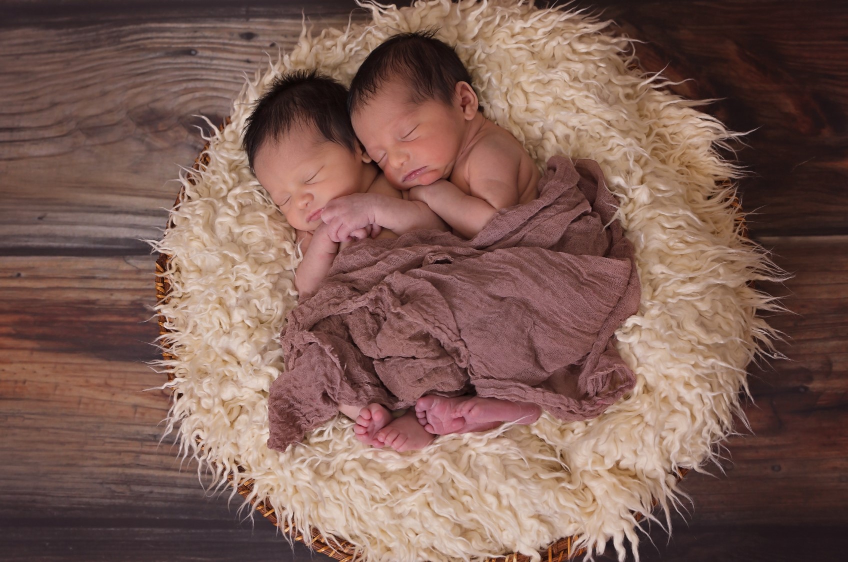 Baby Twins Sleeping Together on a Fluffy Bed Sheet