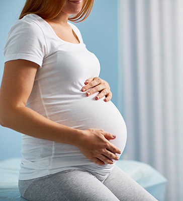 Pregnant Woman Holding Hands on her Stomach