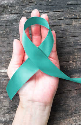 Hand Holding a Green Cancer Symbol