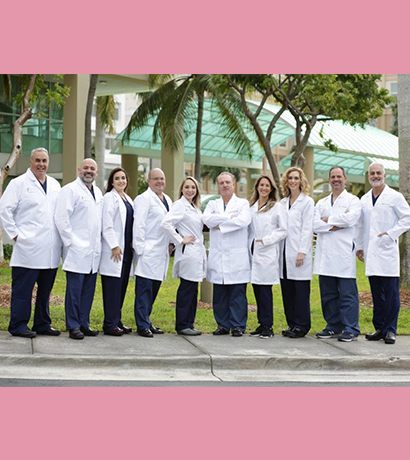Team of Doctors in White Coats Posing In Outside the Clinic