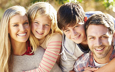 Happy Family Hugged Outside and Bathed in Sunlight