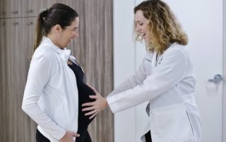 Female Doctor Holding Hands on a Pregnant Woman's Stomach