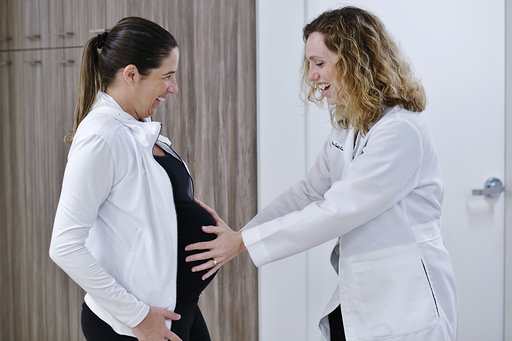 Female Doctor Holding Hands on a Pregnant Woman's Stomach