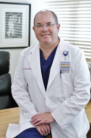 Bold Doctor Wearing Glasses Sitting on a Table