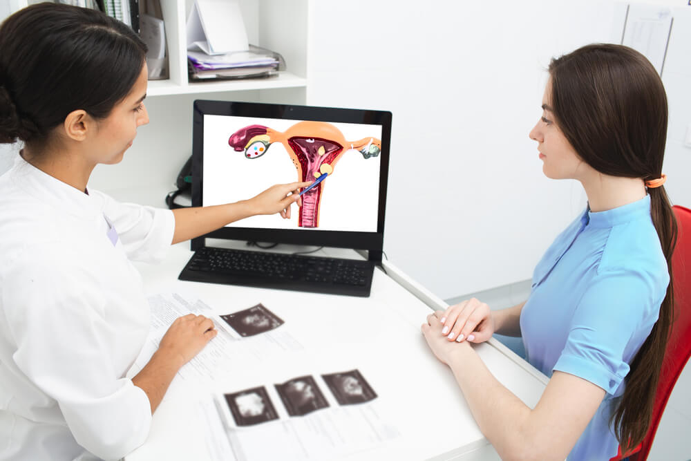 Gynecologist Explains to a Woman About a Disease of the Uterus, Showing an Endometrial Polyp on Her Laptop