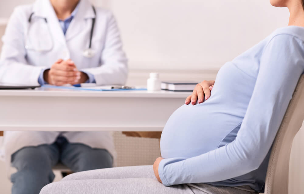 Unrecognizable Pregnant Lady Visiting Doctor Sitting in His Office.