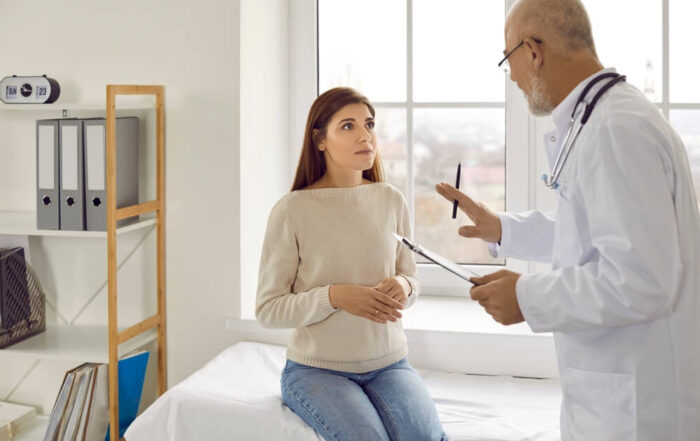 Experienced Senior Doctor at Modern Clinic Talking To Nervous Female Patient.