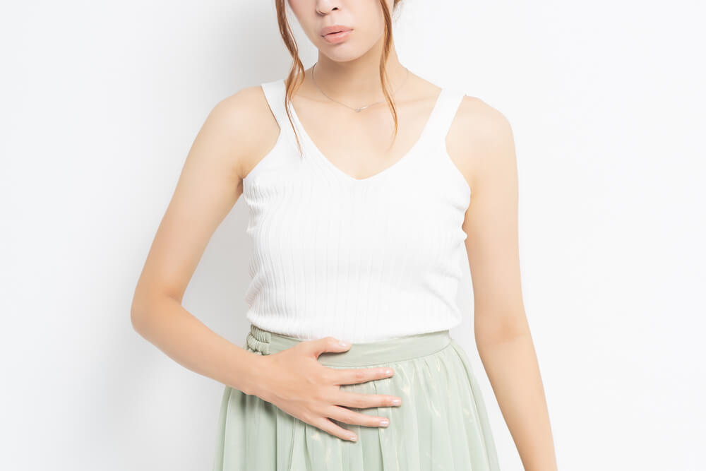 Young woman putting her hand on her stomach