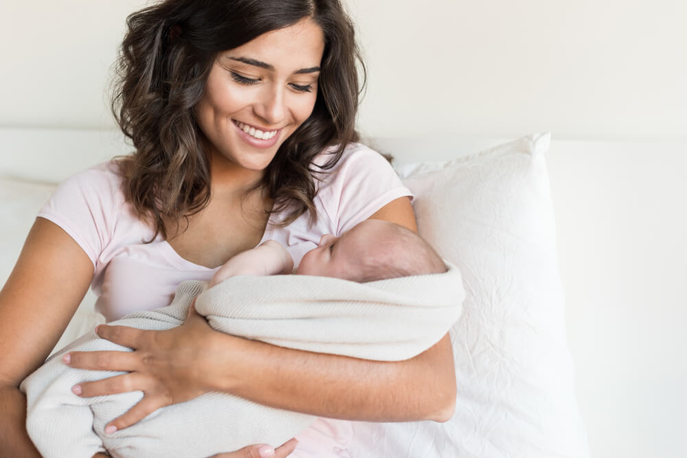 Lovely mother holding newborn baby in arms