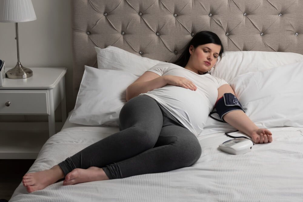 Pregnant woman measuring her blood pressure