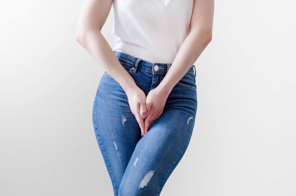 Young Woman in Jeans Standing With Hands Between Legs