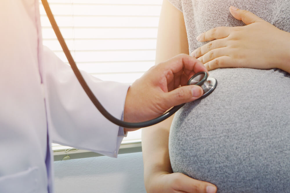 Obstetrician Using Stethoscope Listening to Heart Rate of Fetus