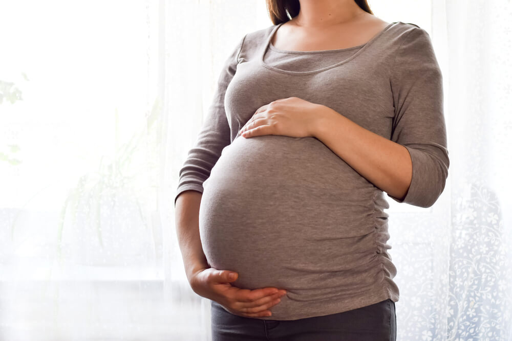 Pregnant Woman With Big Belly at Window.